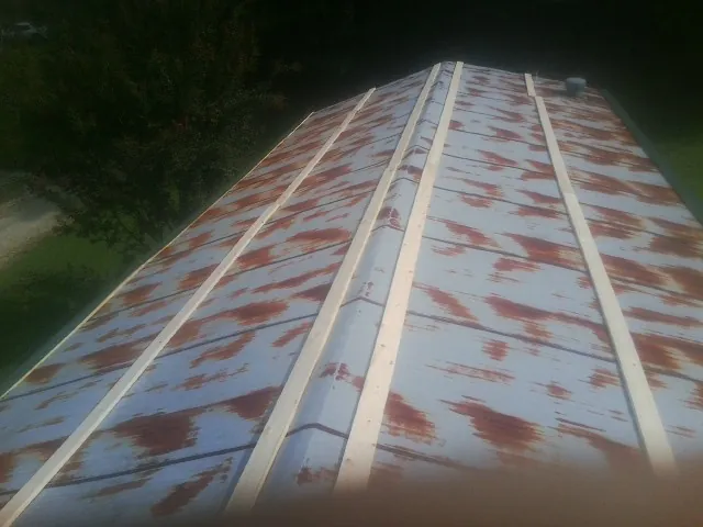 Rusted metal roof panels with new wood purlins before replacement — Storm Damage Roof Repair in Buck Creek by Roofing Brothers