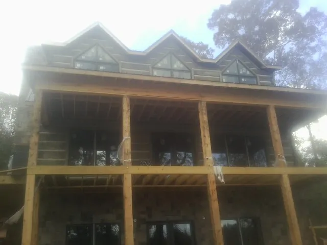 Dormers and porch framing on a large log home under construction — Roof Coating work by our crew in Buck Creek