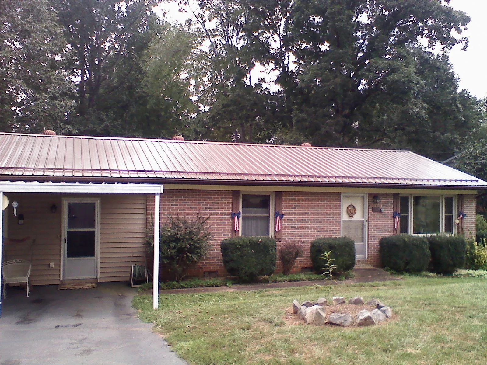 Bronze metal roof and carport on a brick ranch home — Roof Repair work by our crew in Buck Creek