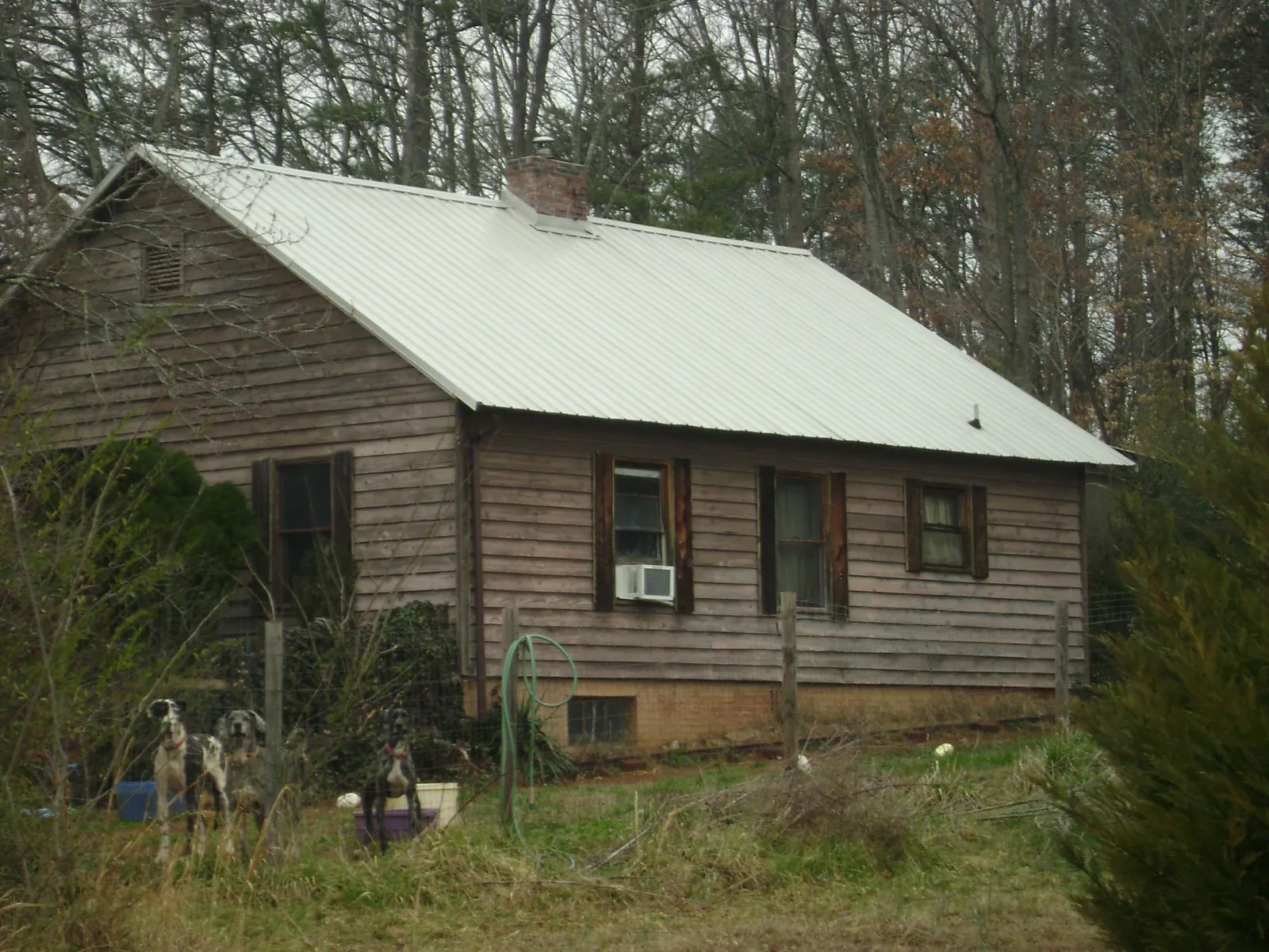 White metal roof on an old wood sided farmhouse, from a Metal Roof Installation job in Buck Creek